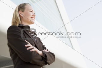 Businesswoman standing outdoors by building smiling