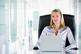 Businesswoman in office with a laptop