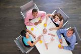 Four businesspeople in boardroom with a baby lying on the table