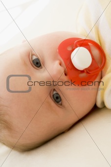 Baby lying indoors with soother