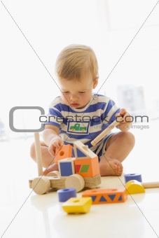 Baby indoors playing with truck