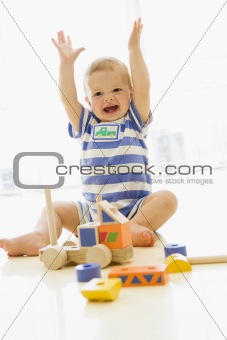 Baby indoors playing with truck