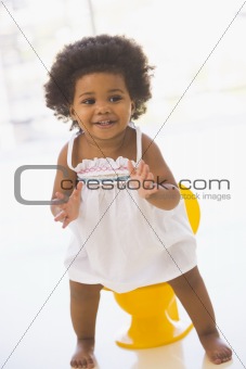 Baby indoors going on potty smiling
