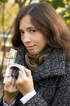 young girl holding roll of dollars