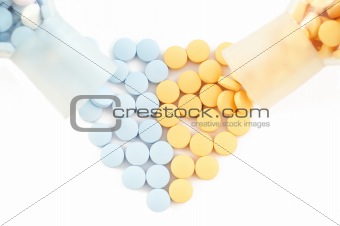 pills and drugs forming heart on white