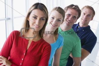 Four people standing in corridor smiling