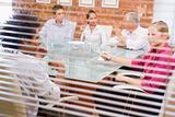 Five businesspeople in boardroom through window
