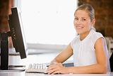 Businesswoman sitting in office with computer smiling