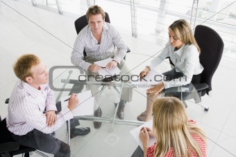 Four businesspeople in boardroom with paperwork