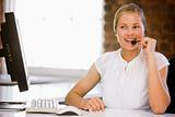 Businesswoman wearing headset in office smiling