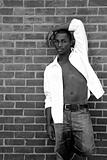 African American Man Leaning Against  a Brick Wall With Chest Ex