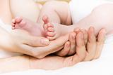 Baby foots in hands of parents