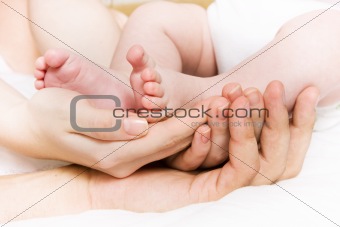 Baby foots in hands of parents