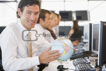 Businessman in office space with a desk globe