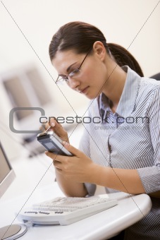 Woman in computer room using personal digital assistant