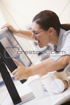 Woman in computer room grabbing her monitor and screaming