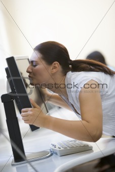 Woman in computer room kissing monitor