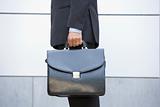 Businessman holding briefcase outdoors
