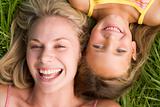 Woman and young girl lying in grass laughing