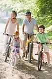 Family sitting on bikes on path smiling