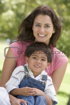 Woman and young boy sitting outdoors smiling