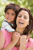 Woman and young boy embracing outdoors smiling