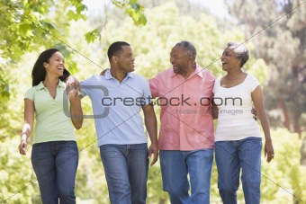 Two couples walking outdoors arm in arm smiling