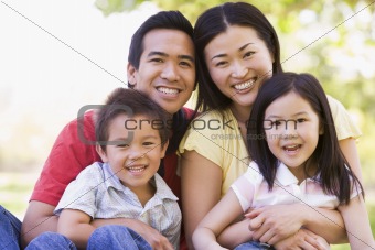 Family sitting outdoors smiling