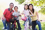 Family with children on bikes outdoors smiling