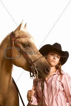 Cowgirl in hat holding her horse by bridle