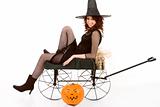 teen girl in Halloween costume on cart by pumpkin