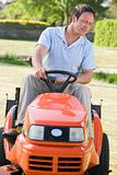 Man outdoors driving lawnmower
