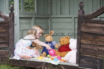 Young girl in shed playing tea and smiling