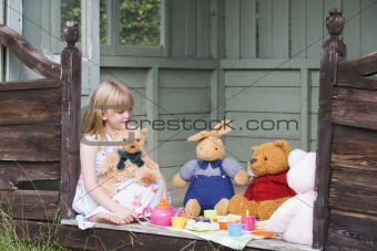 Young girl in shed playing tea and smiling