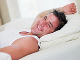 Man lying in bed laughing
