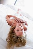 Woman lying in bed laughing