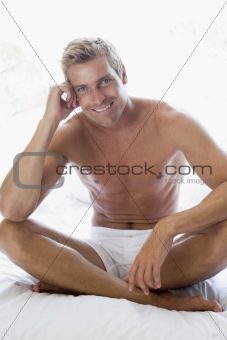 Man sitting on bed smiling