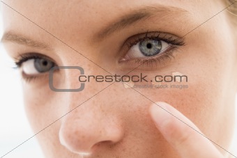 Woman applying concealer