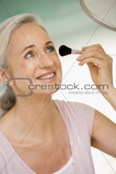 Woman with makeup brush smiling