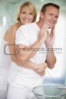 Couple in bathroom embracing and smiling