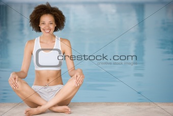 Woman sitting poolside smiling