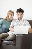Couple relaxing at home with a laptop computer