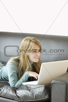 Young Woman with her Laptop Laying on a Sofa