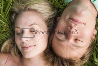Couple lying in grass sleeping