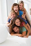 Five people in living room piled up smiling