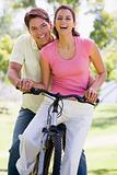 Couple on a bike outdoors smiling