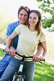 Couple on a bike outdoors smiling
