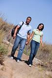 Couple walking on path holding hands and smiling