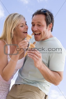 Couple outdoors eating ice cream and smiling