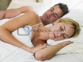 Couple lying in bed sleeping